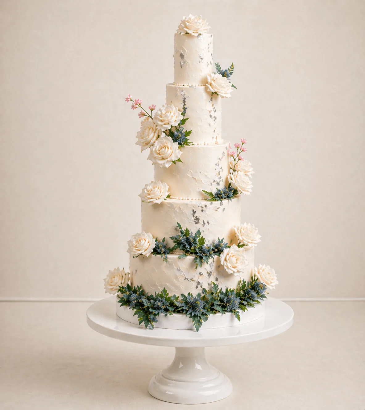 A five-tier wedding cake with thistle and rose decorations.